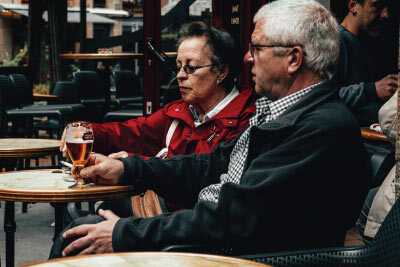 Man and Woman Sitting Outside Restaurant Smoking Cigarettes