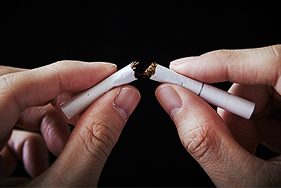 Man Breaking Cigarette Into Two