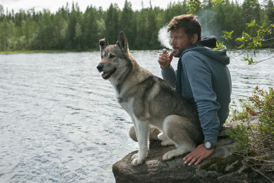 Man Smoking With a Dog by the Lake