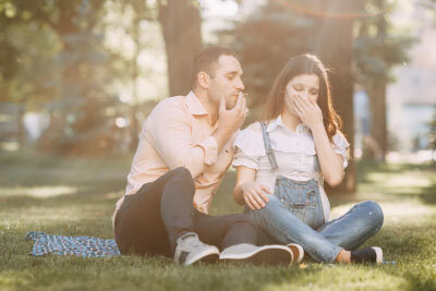 Man Smoking With Pregnant Woman in a Park