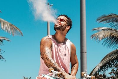 Man Vaping E-Liquids in the Summer by the Beach