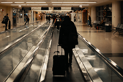 Woman Walking Through Airport With Handheld Language